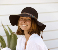 woman wearing a floppy winter hat and smiling.