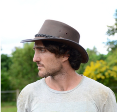 A man wearing an Australian leather outback hat.