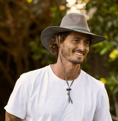 man wearing a white t-shirt and a dark green mesh fishing hat