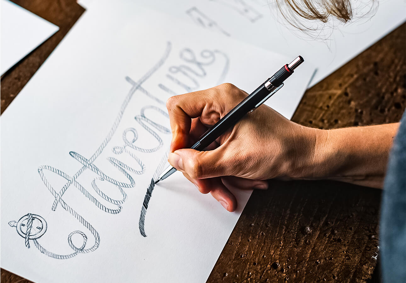 A person doing a hand lettering sketch.