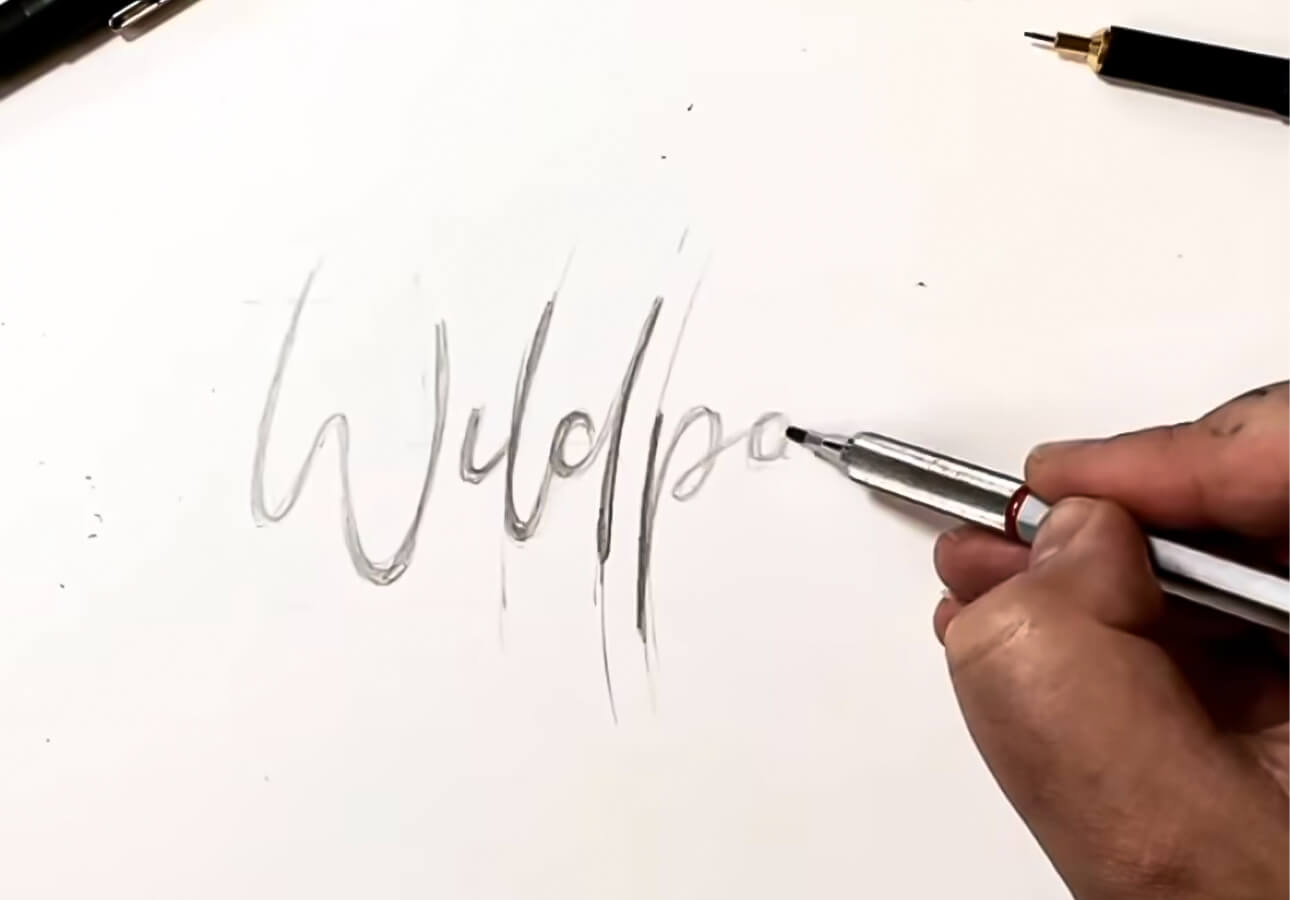 An image depicting an artist working on a hand lettering sketch.