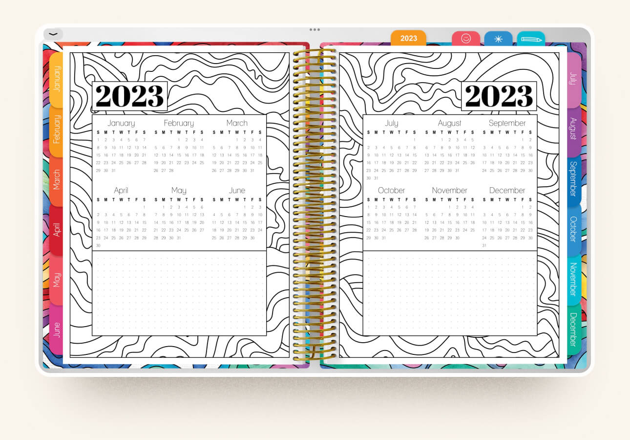 Image of the yearly calendar on a two-page spread with a spiral binder dividing the pages of the Coloring Planner.