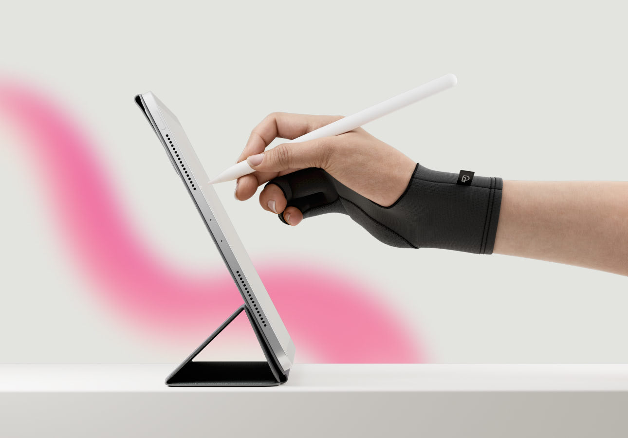 A hand wearing Paperlike’s Drawing Glove and holding an Apple Pencil hovers above an iPad propped up on a white surface.