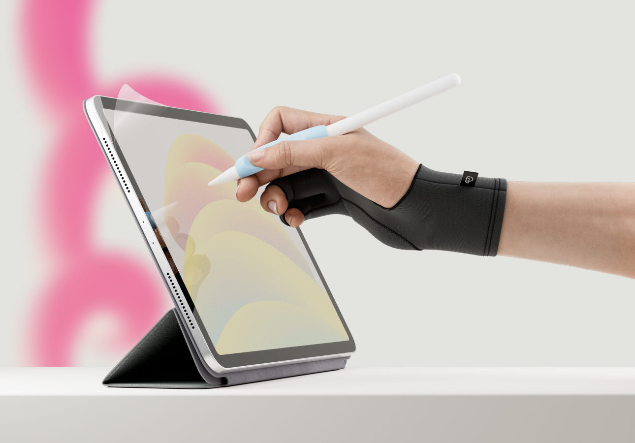 An iPad with Paperlike’s Screen Protector is propped up on a white surface, and a hand wearing Paperlike’s Drawing Glove and holding an Apple Pencil draws on it.