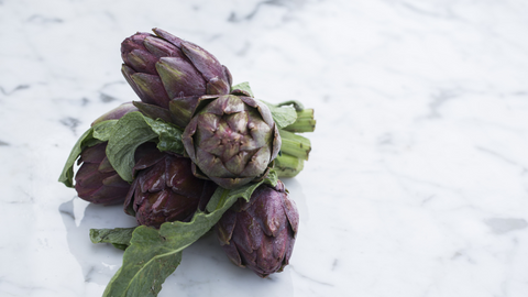 Purple artichoke on table