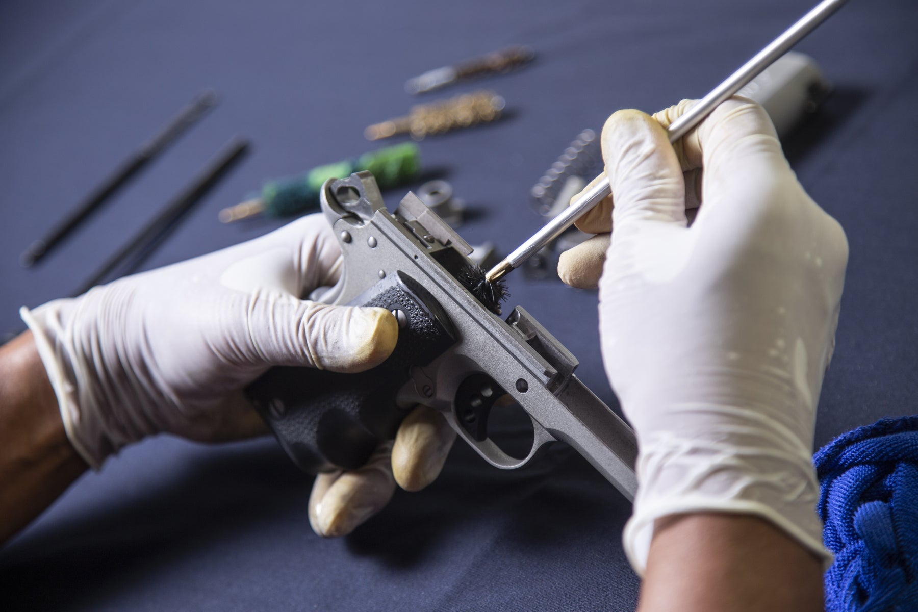 Person cleaning pistol with snake bore