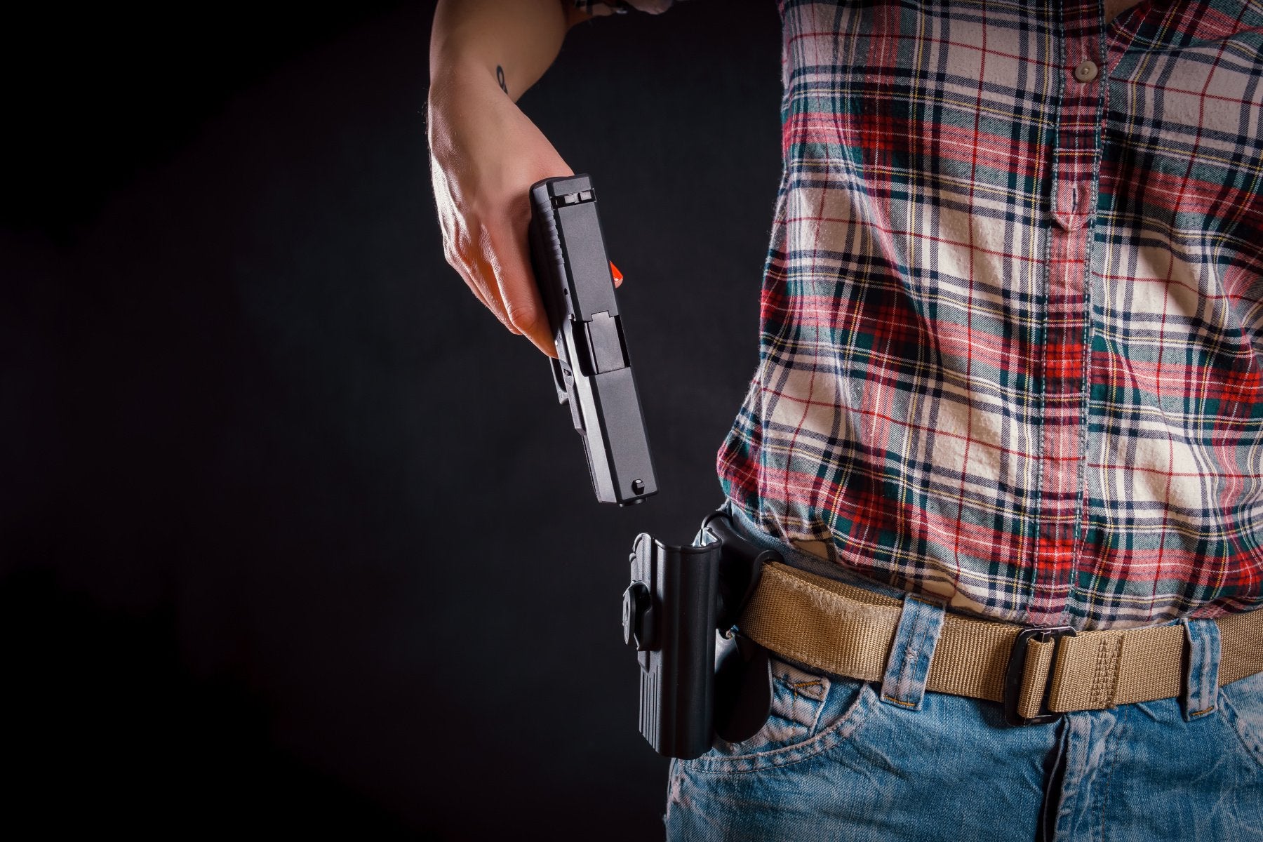 Woman removing gun from her holster