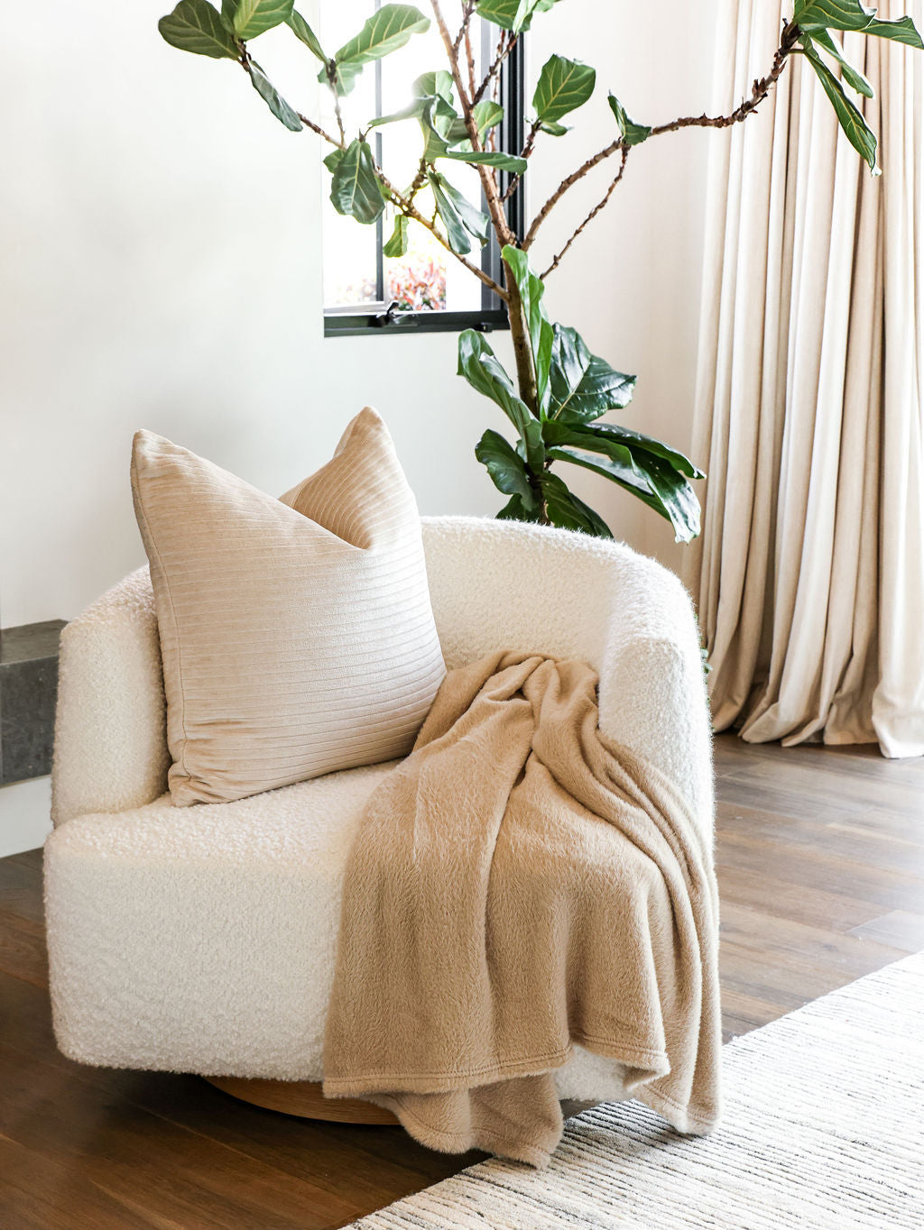 Embrace throw blanket in Oat draped on a chair