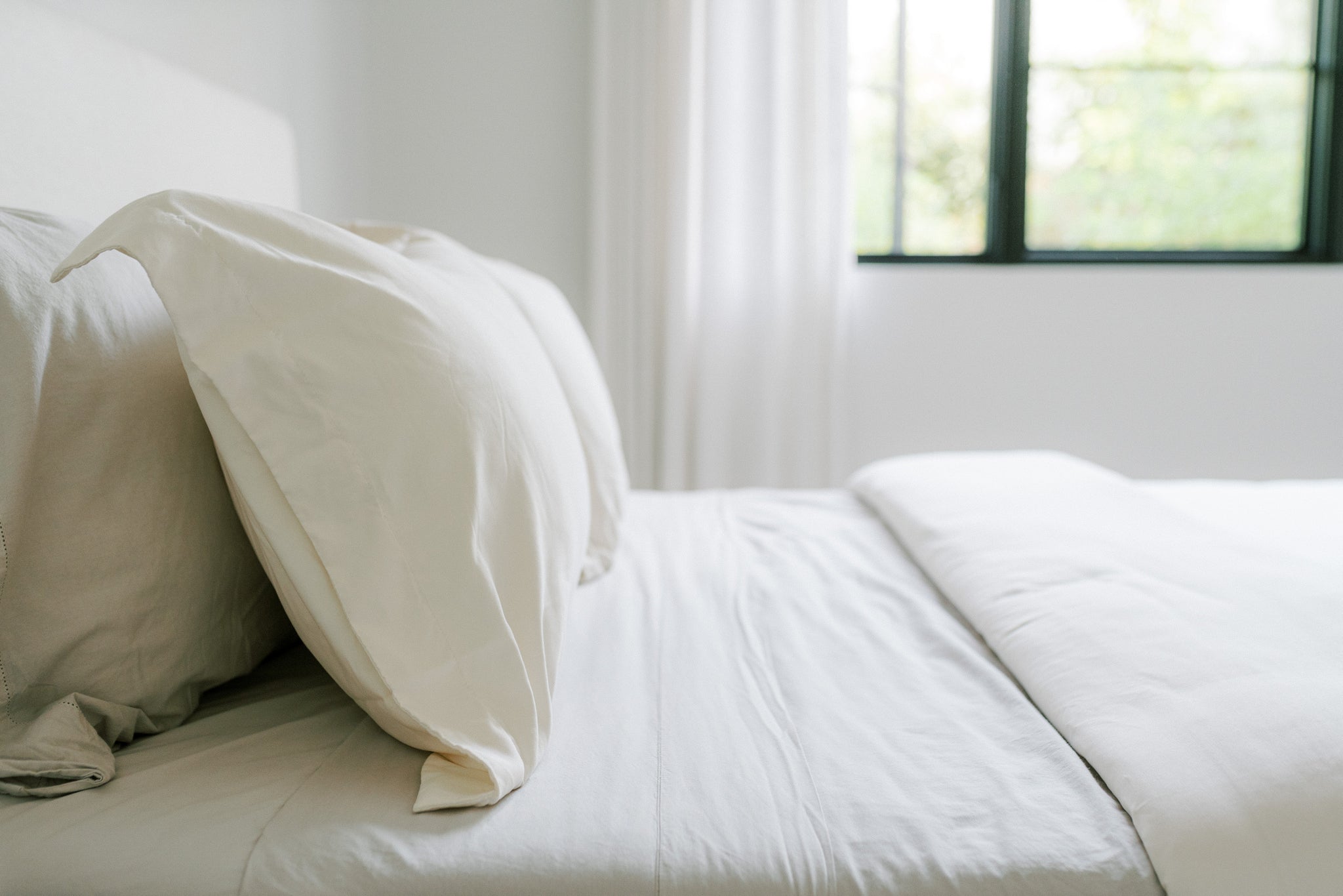 Crisp white bed sheets neatly folded on a bed