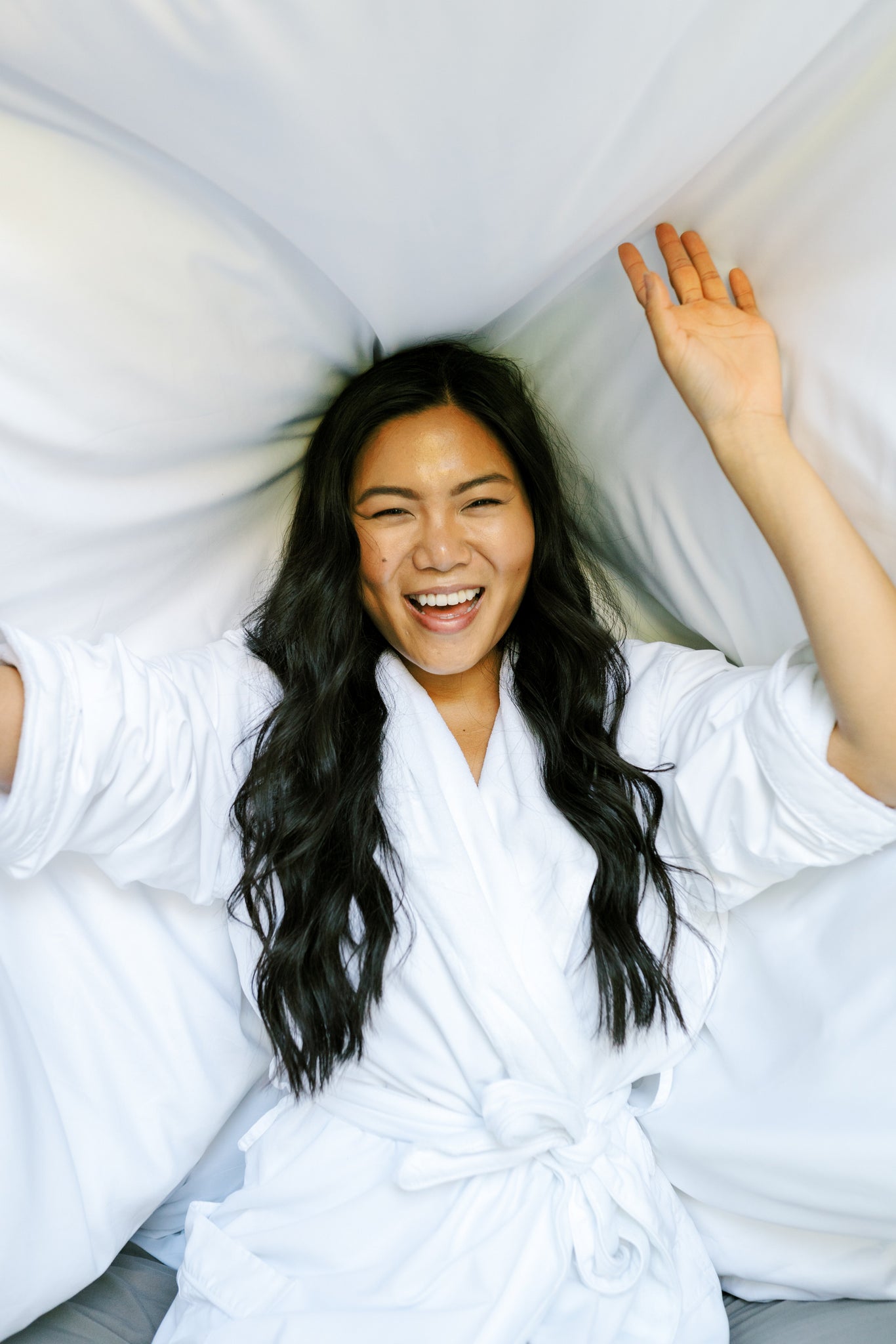 A woman changing up her bed linens for the summer season