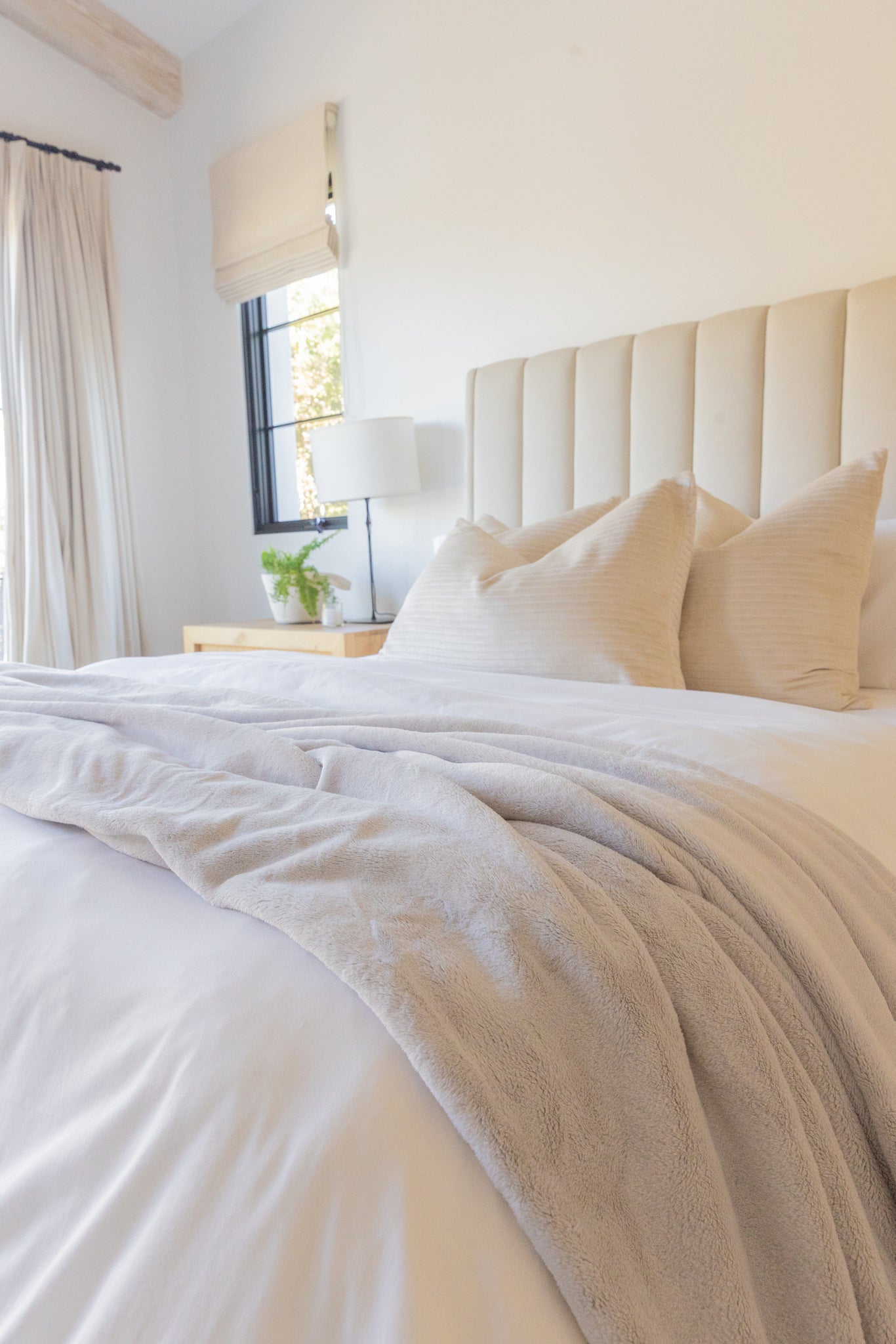 Calming neutral bedroom with soft, creamy white bedding and Whisper Gray Cloud Blanket