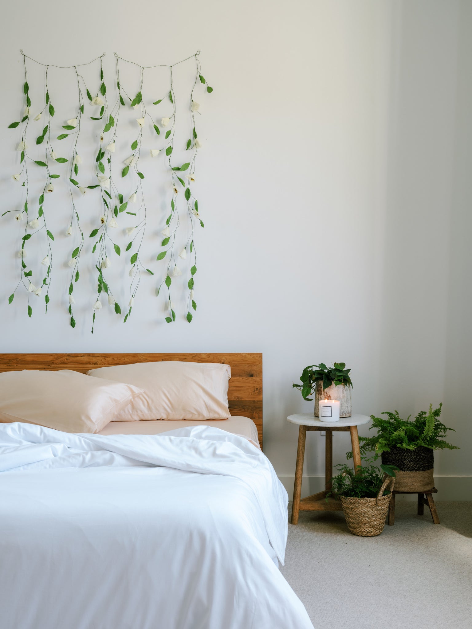 guest room with a bedside table with a reading lamp and a pot plant