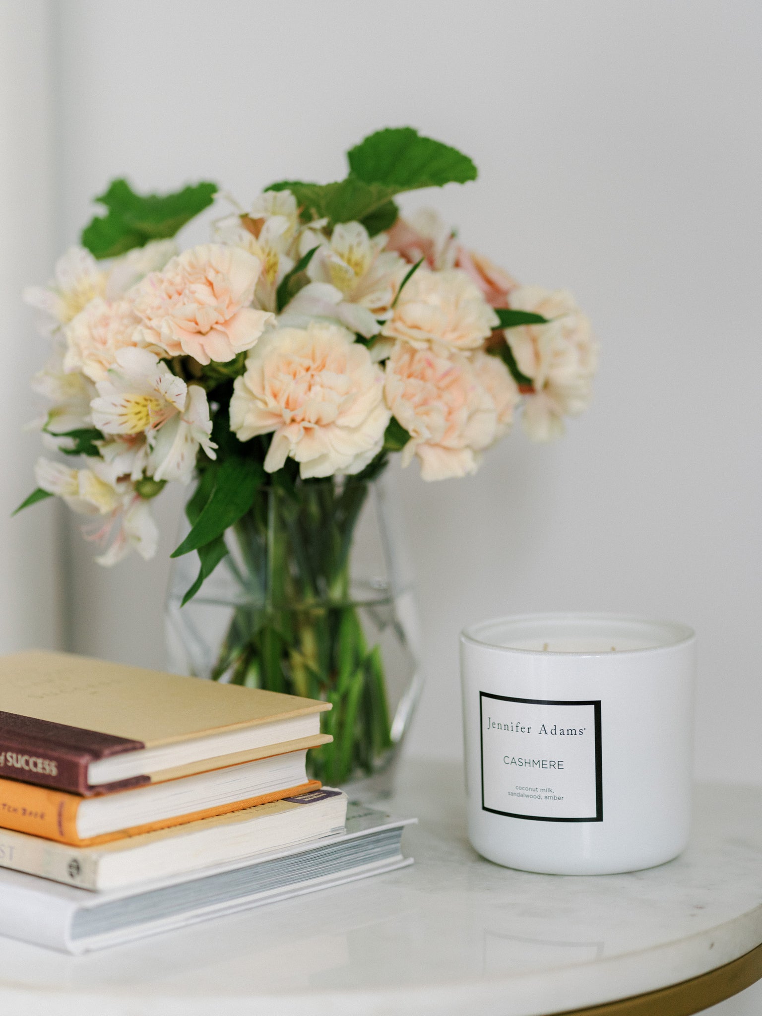 A stack of books on a nightstand in a tranquil bedroom