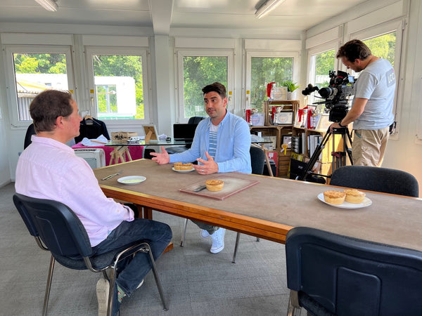 Christian and Chris Bavin at table with camera