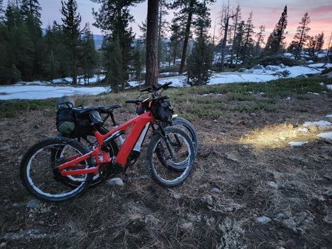 Two electric bikes with bikepacing gear in a snowy clearing