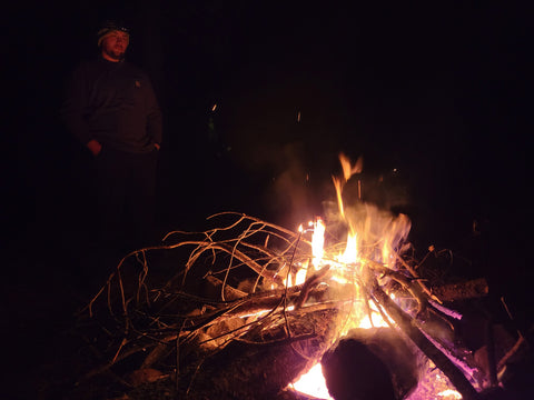 Big bonfire in the dark with man standing next to it