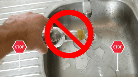 A hand is pouring a bottle of rubbing alcohol down the sink, and there is a big red circle with a line through it over the hand and a stop side on either side. 