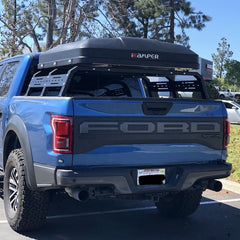 Blue Ford F-150 Raptor with iKamper Skycamp mini Roof Top Tent installed on bed rack