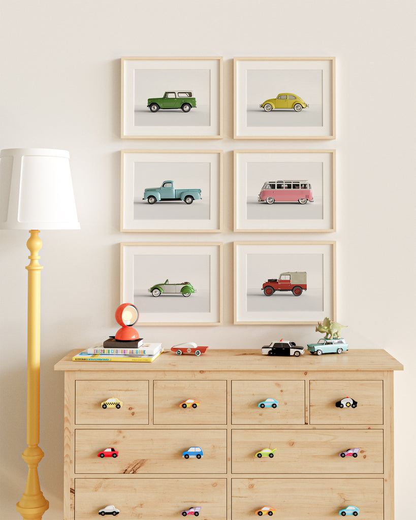 A child's room with an IKEA dresser with custom DIY wooden car drawer pulls and six framed car prints on the wall