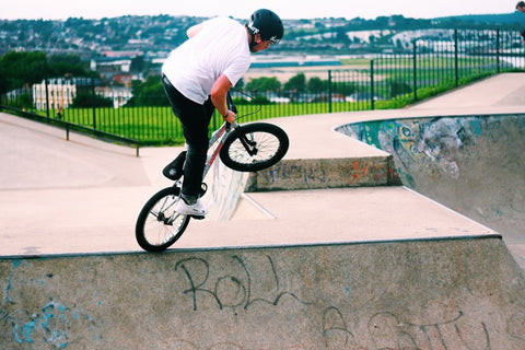 A Man rides a BMX bike at a skate park