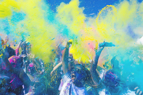 Blue and yellow colour powder covering a crowd of people