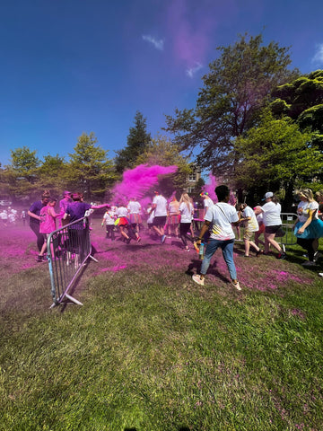 People throwing pink colour powder at a colour run