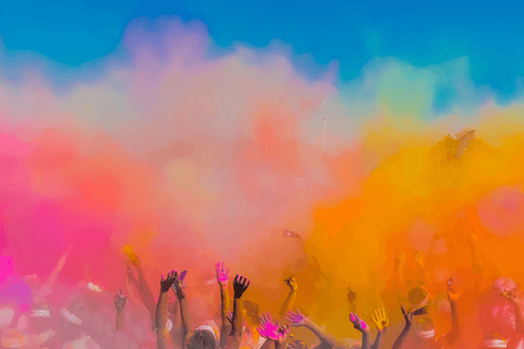 A large group of people celebrating in a big cloud of colour powder