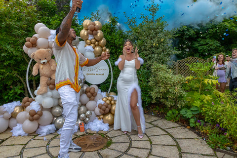 Couple celebrating their gender reveal with a blue colour fountain