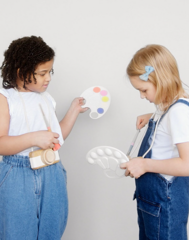 Two young children dressed as artists with a paintbrush and pallette