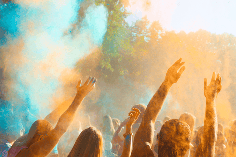 A group of people throwing colour powder in the air