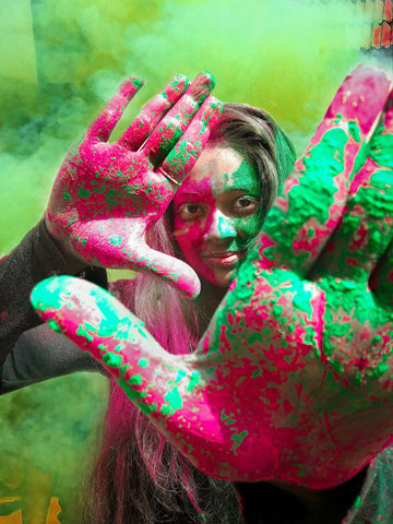 Woman covered in pink and green colour powder