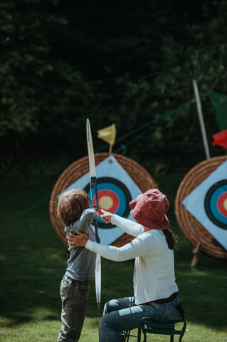 Child playing archery, aiming for target