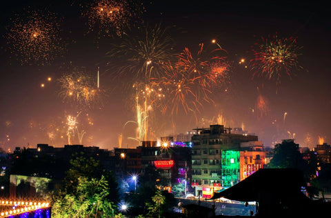 Fireworks exploding over a city at night to celebrate Diwali