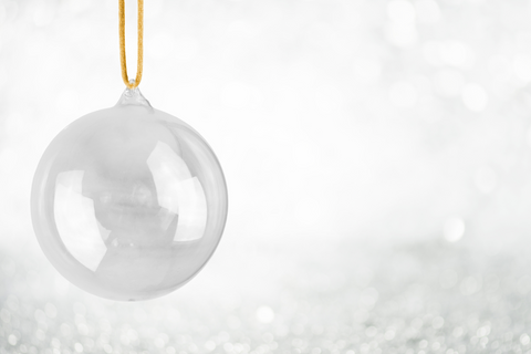 A plain transparent bauble against a snowy background