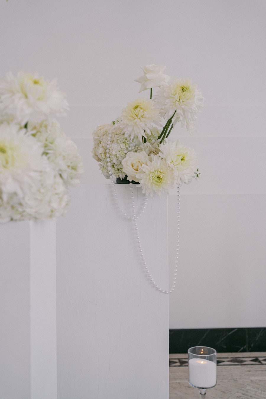 Shot of a floral arrangement full of white roses, hydrangea, and calathea.