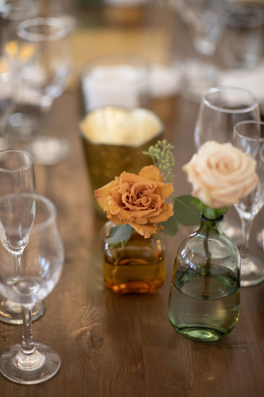 Bud vases with single roses, toffee and cream, placed with the table centerpieces.