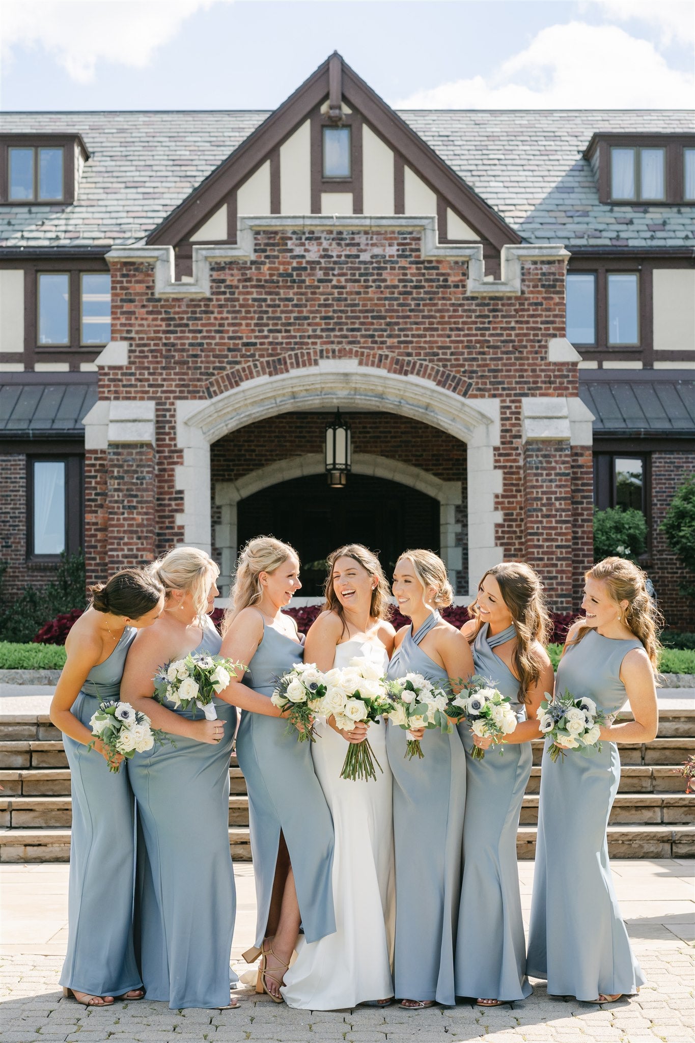 bride with bridesmaids holding white bouquets