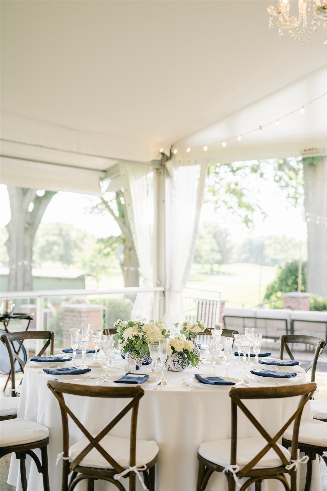 round table with grouping of blue and white vessels with white flowers