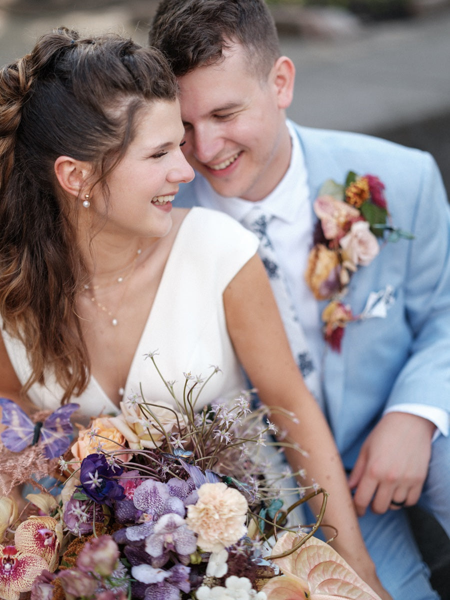 Bride and groom together with the whimsical bridal bouquet and climbing boutonniere.