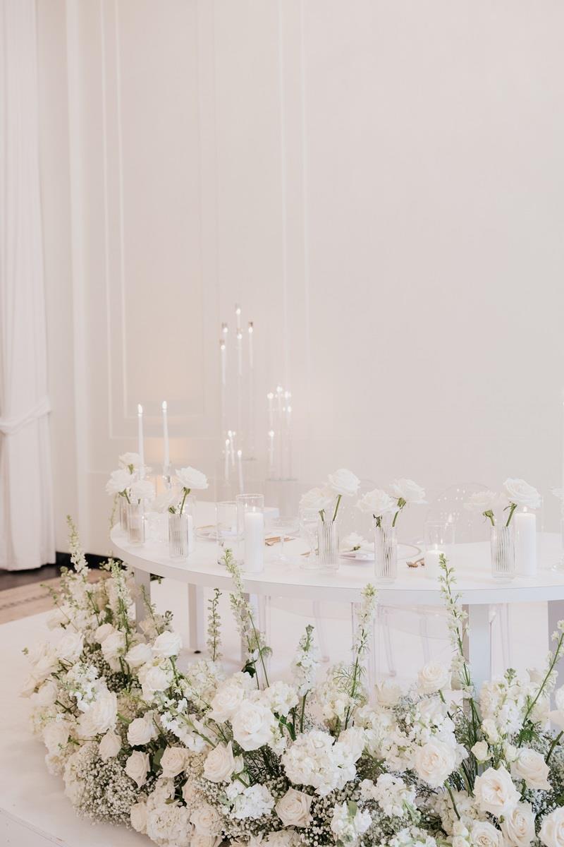 Close up of the sweethearts table showing the florals and budvases on top.