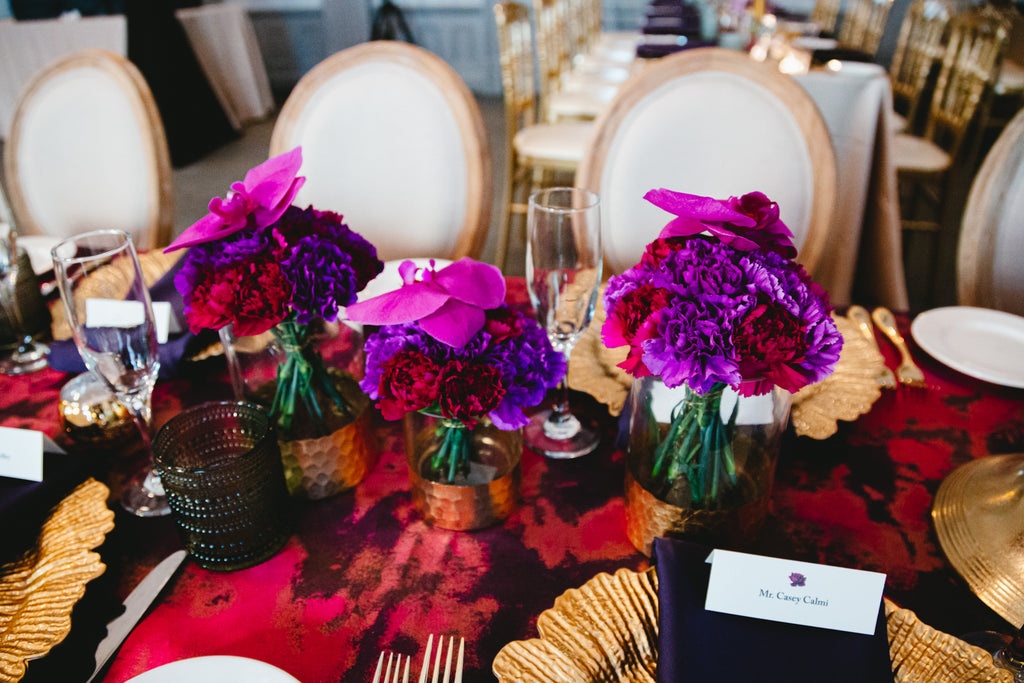 red and purple carnations with purple orchids in vases