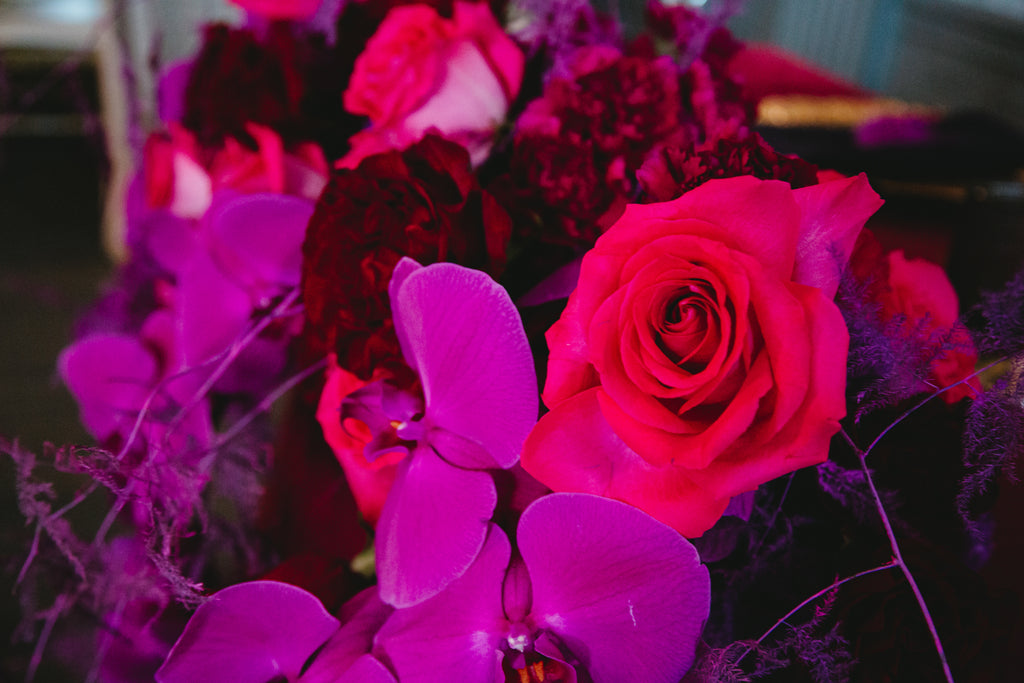 closeup of red roses and purple orchids