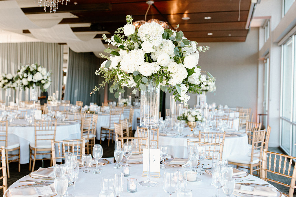 Tall white floral centerpiece on round guest table 