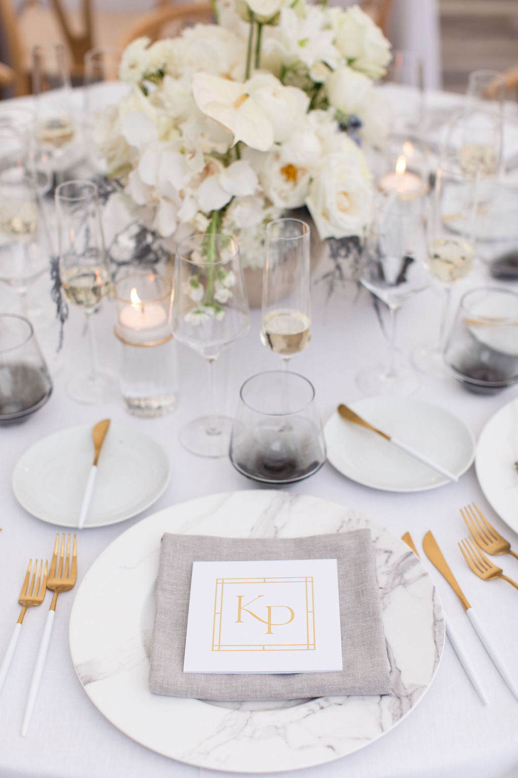 round table with white centerpiece and place settings