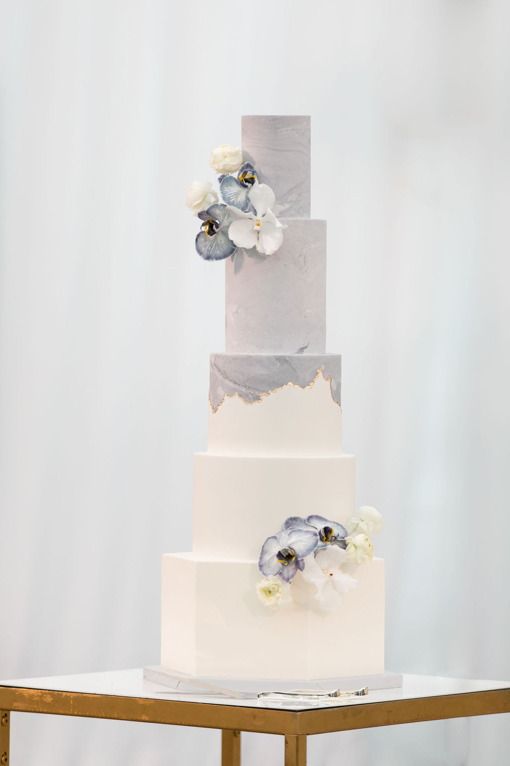 five tiered wedding cake with floral clusters