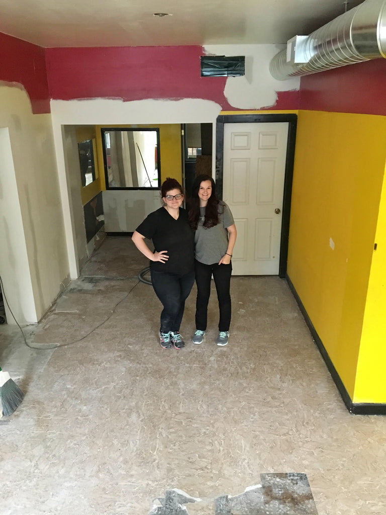 Kat and Lindzi standing in the emptied out cafe space.