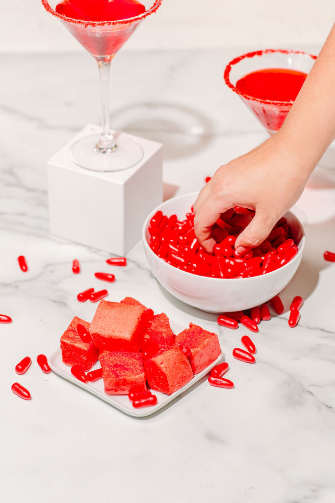 Reaching into a bowl of red hot candies while we build a cocktail inspired by our Red Hawt marshmallows