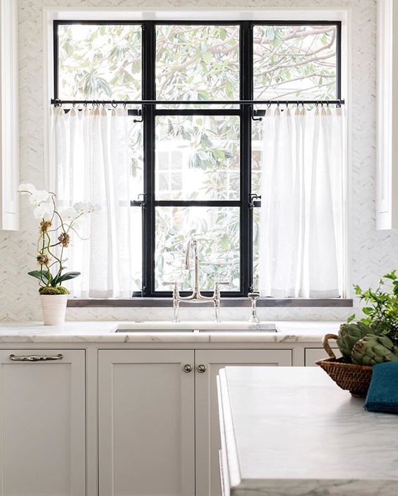 kitchen with marble counter top and spring cafe curtains