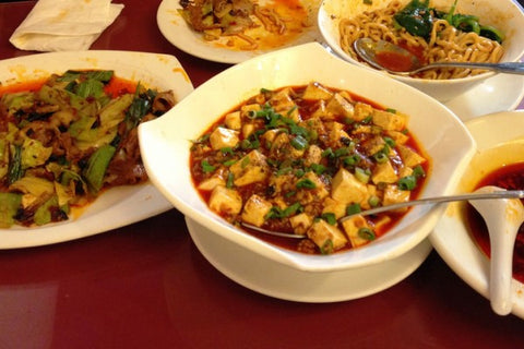 Image of Chinese food in plates on a table that was delivered by Bowen Food Delivery 