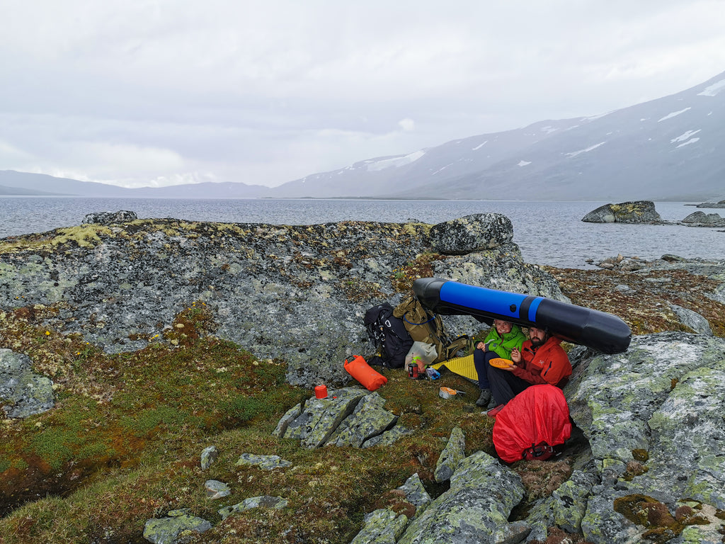 Uventet nedbør er ikke øverst på ønskelista i fjellet. Spesielt når man tenker å spise lunsj. I mangel av trær er det vel kjekt å kunne sette seg under et oppblåsbart og tett tak? Det synes ihvertfall Mads og Marte. 